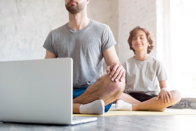 Kid y su padre haciendo deporte en casa