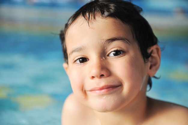 Kid tendo tempo feliz na água da piscina