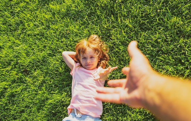 Kid tirar de la mano del padre sígueme de la mano caminando en un día soleado niño sosteniendo la mano del hombre y le