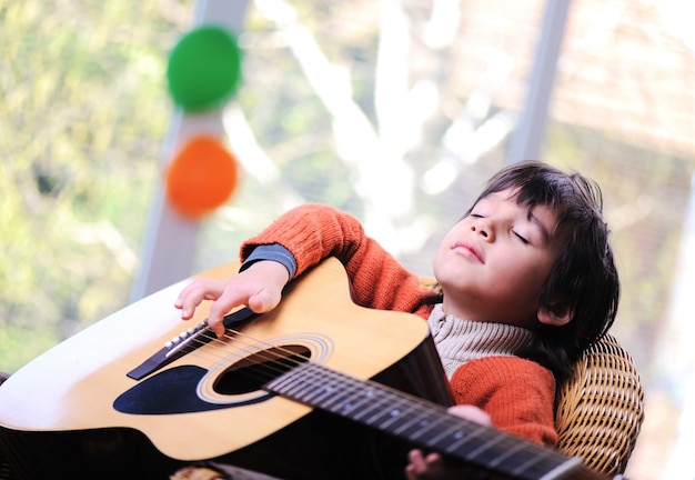 Kid tocando violão em casa