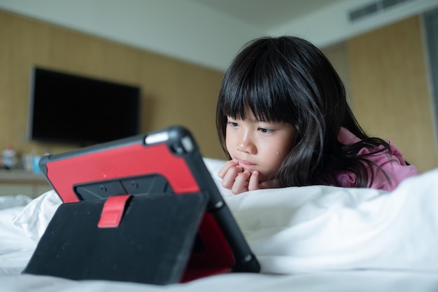 Kid Watching Tablet auf dem Bett Kind süchtig nach Cartoon