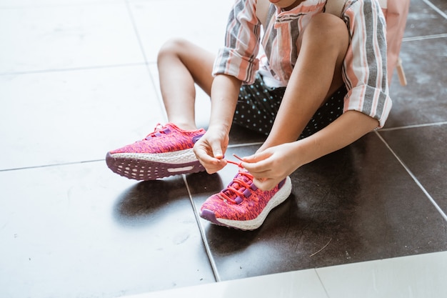 Foto kid zieht ihre schuhe alleine an