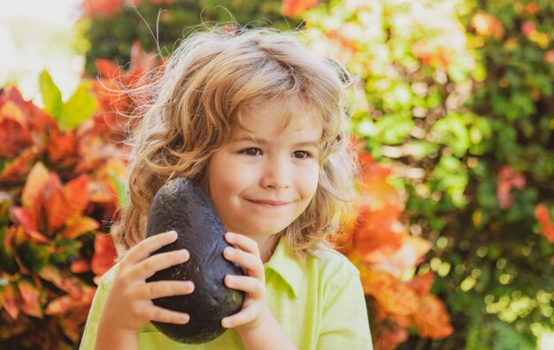 Kids Sommer Vitamin Kleines entzückendes Kind mit Avocado Vitamin und gesunde Ernährung für kleine Kinder Porträt eines schönen Kindes