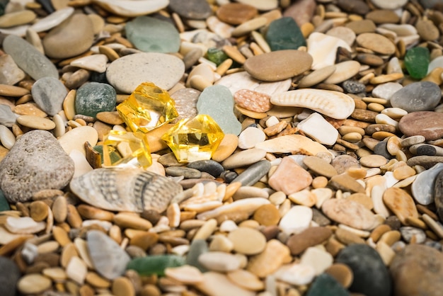 Kieselstrand mit gelbem Bernsteinsteinhintergrund