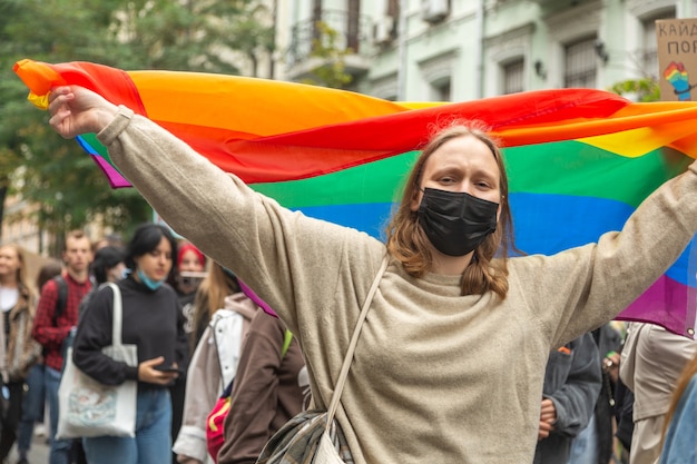 Foto kiev, ucrânia - 09.19.2021: comunidade lgbtq na parada do orgulho lgbt. a menina está segurando uma bandeira do arco-íris se desenrola.