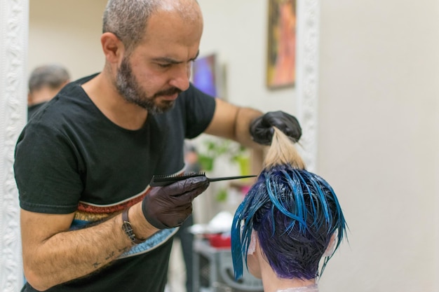 Kiev Ucrania 21 de octubre de 2018 Estilista de peluquería hace coloración del cabello de una mujer en el salón de peluquería