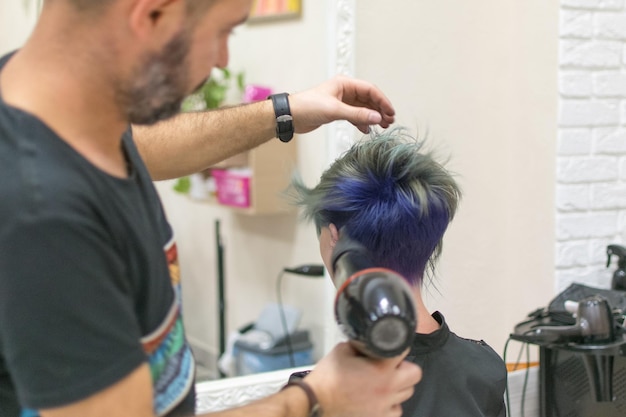 Kiev Ucrania 21 de octubre de 2018 Estilista de peluquería hace coloración del cabello de una mujer en el salón de peluquería