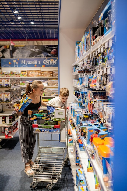 Kiew 6. Januar 2019 Mutter mit ihrem kleinen Sohn im Kinderladen Autos kaufen