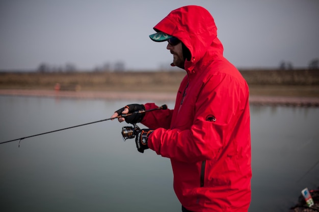 Kiew, Ukraine 16. April 2018. Kaukasischer Fischer fängt Fische mit einer Spinnrute auf dem See.