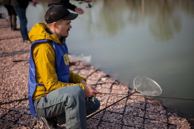 Kiew, Ukraine 16. April 2018. Kaukasischer Fischer fängt Fische mit einer Spinnrute auf dem See.