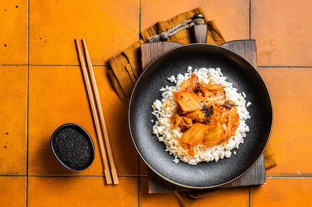 Foto kimchi con carne de cerdo en arroz cocido cocina tradicional coreana fondo naranja vista superior