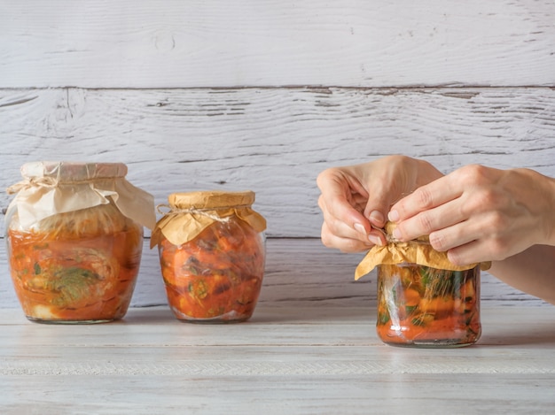 Kimchi coreano en frascos sobre una mesa de madera.