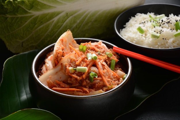 Kimchi e arroz em tigela preta com comida coreana de pauzinho