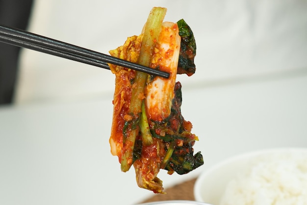 Kimchi mit Stäbchen halten