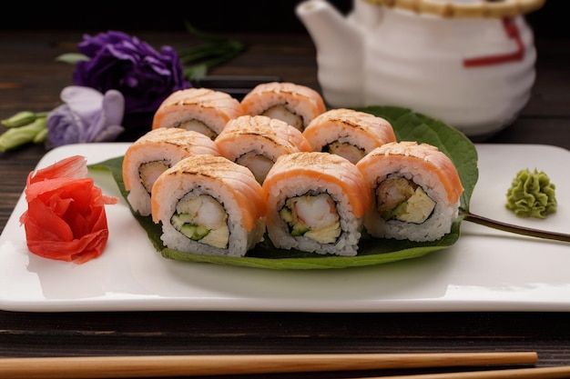 Kimono maki sushi con decoración en un plato sobre un fondo de madera