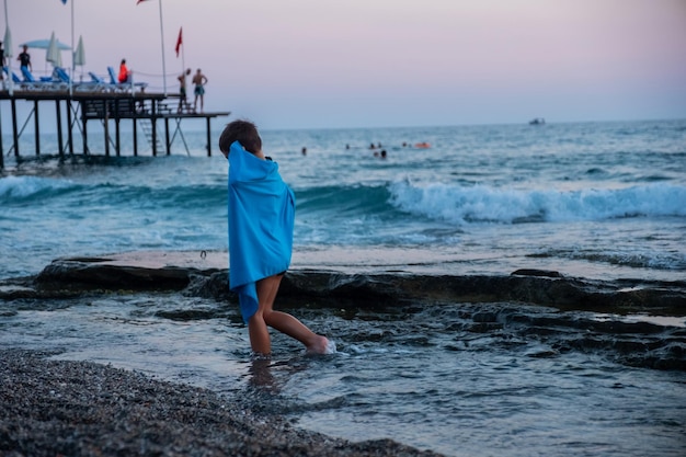 Kind am Strand bei Sonnenuntergang