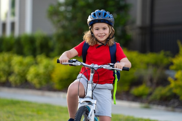 Kind auf dem Fahrrad, Junge mit Helm, der Fahrrad fährt. Kleiner süßer kaukasischer Junge mit Schutzhelm, der Fahrrad fährt
