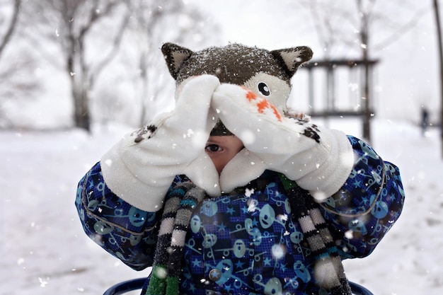 Kind auf dem Schlitten im Winterpark