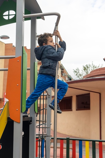 Kind auf dem Spielplatz, der die Stange des Feuerwehrmanns herunterrutscht