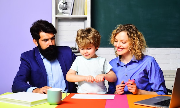 Kind aus der Grundschule mit Eltern in der Schule Lehrer helfen Kind aus der Grundschule zu machen