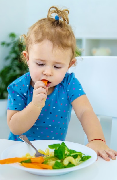 Kind Baby isst Nudeln mit Gemüse Selektiver Fokus Essen