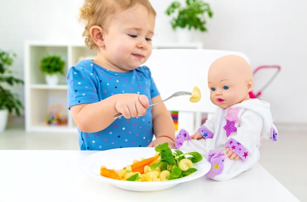 Kind Baby isst Nudeln mit Gemüse Selektiver Fokus Essen