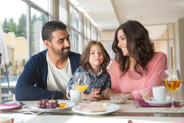 Kind beim Frühstück mit ihrer Mutter und ihrem Vater