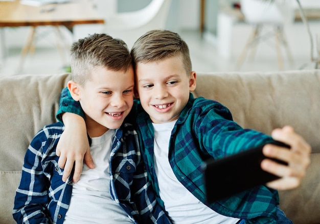 Kind, Bruder, Freund, der Spaß hat, selfie Handy-Technologie Smartphone glückliches Kind zu nehmen
