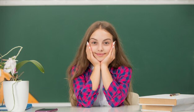 Kind, das bereit ist, teenager-mädchen zu studieren, lächelt zurück zum schulwissenstag-bildungskonzept