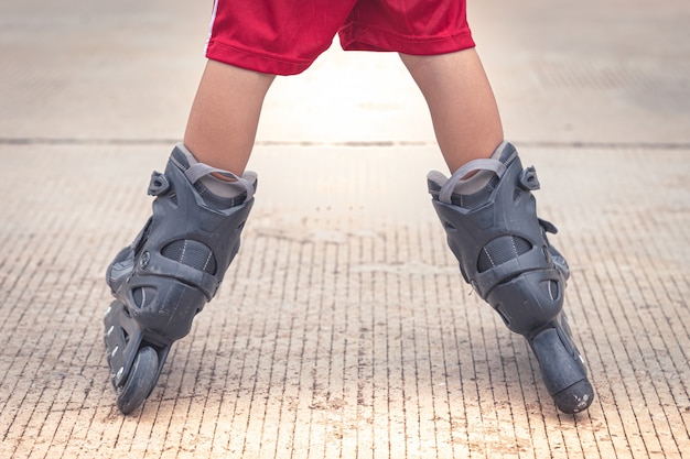 Kind, das das Rollerblading in der Zementstraße spielt