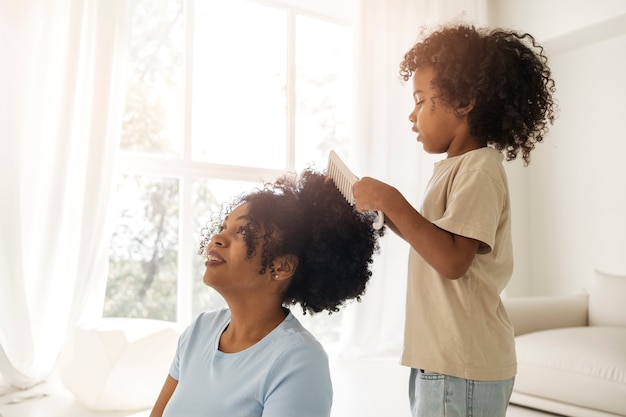 Foto kind, das die haare der mutter bürstet, seitenansicht