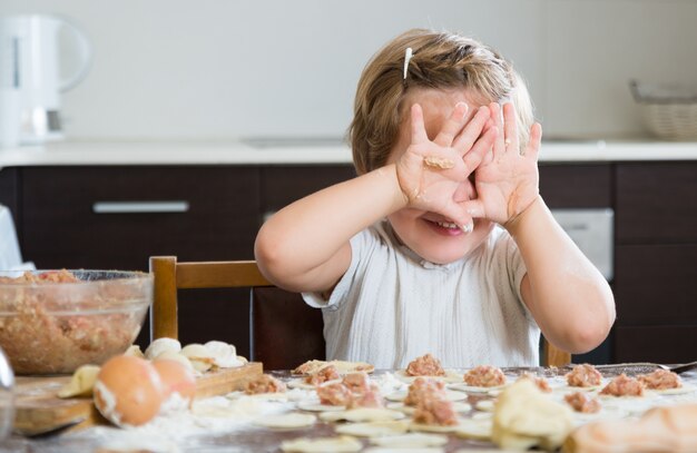 Kind, das Fleischmehlklöße kocht