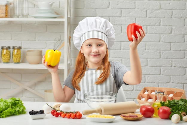 Kind, das gelben und roten Paprika hält