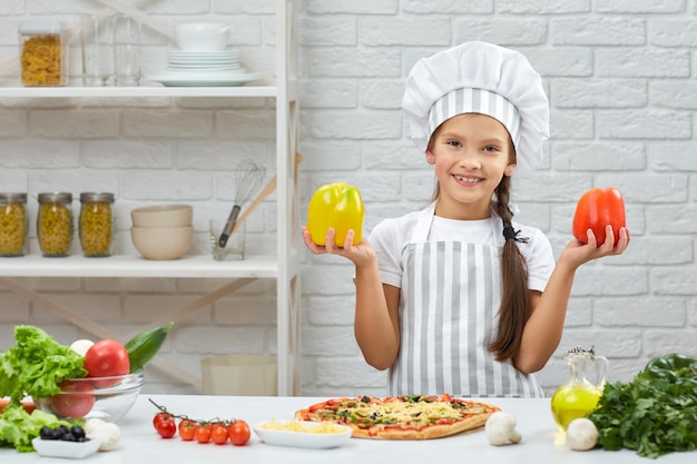 Kind, das gelben und roten Paprika hält