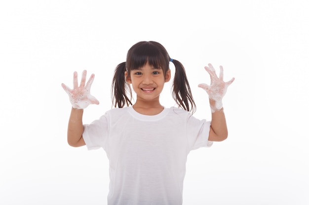 Kind, das Hände wäscht und Seifenpalmen zeigt