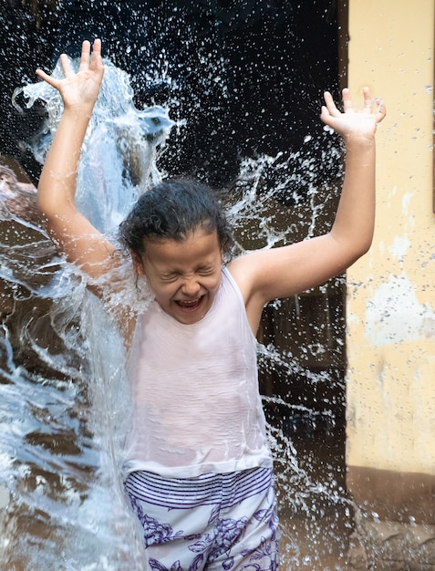 Kind, das im Hof mit Wasser im brasilianischen Sommer spielt