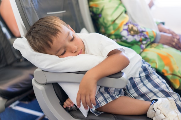 Kind, das innerhalb des Flugzeuges während des Fluges schläft