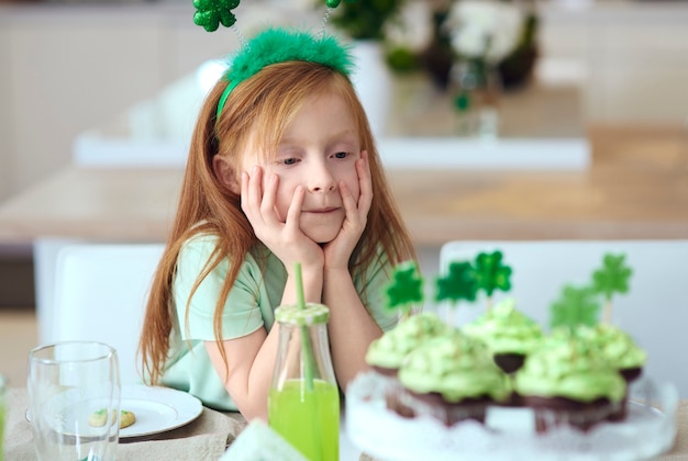 Kind, das köstliche Cupcakes betrachtet