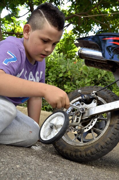 Kind, das mit einem Mini-Fahrrad spielt, Kind, das ein Fahrradradrad auf seinem Mini-Moto benutzt