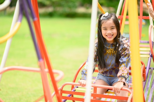 Kind, das Spaß auf Spielplatz habend spielt