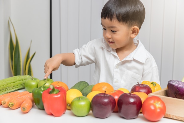 Kind, das über Nahrung lernt, wie man frisches Obst und Gemüse essen wählt.