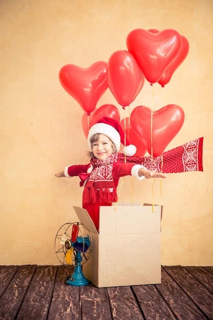 Kind, das zu Hause spielt. Weihnachtsgeschenk. Weihnachtsferienkonzept