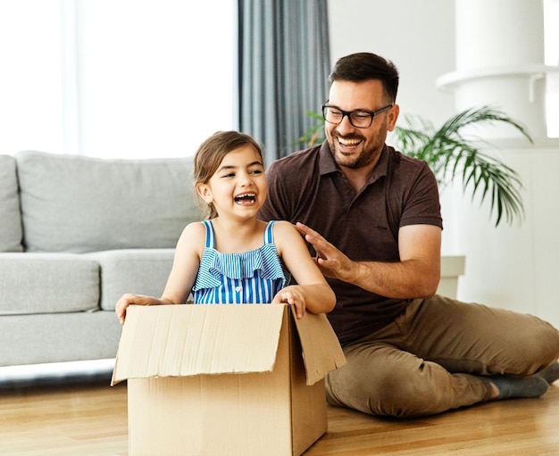 Kind Familie Vater Spaß glücklich Mädchen Glück Tochter Box zusammen Umzug Umzug Karton