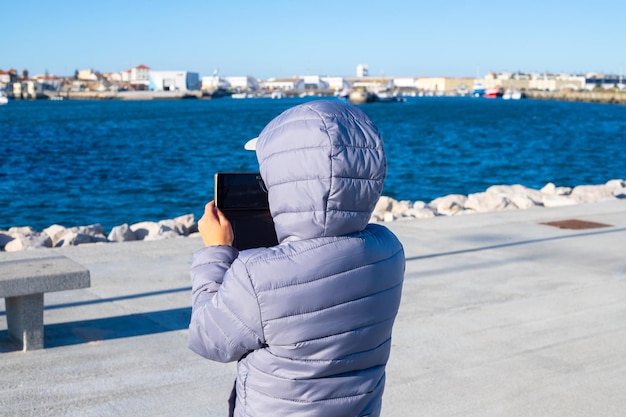 Kind fotografiert das Meer mit seinem Smartphone