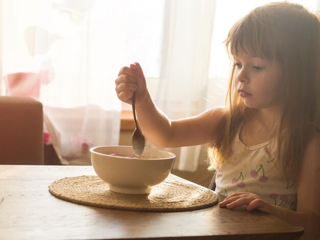 Kind frühstückt mit Maisflocken und Milch