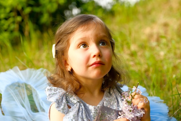 Kind geht im Park kleines Mädchen in einem blauen Kleid gekleidet