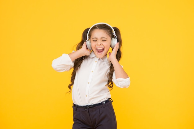 Kind genießt Musikklang Audio-Schulung Hausunterricht Kleines Mädchen Schüler Kopfhörer Kind glücklich Musik hören Hörbuch Bildung und Spaßkonzept Online-Schulung Hörstunde Singen Sie ein Lied