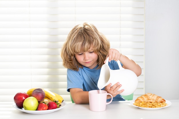 Kind gießt ganze Kühe Milch Kind Junge isst gesundes Bio-Lebensmittel gesundes Gemüse mit Vitaminen p