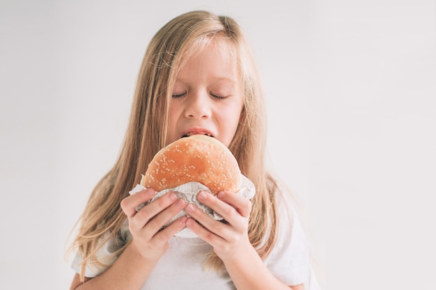 Kind hält ein Stück Hamburger