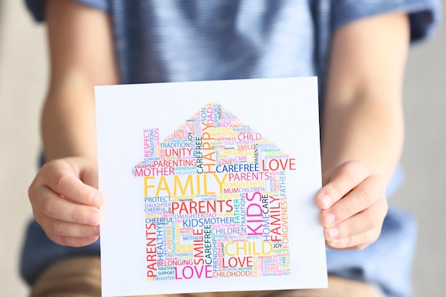 Foto kind hält zeichnung bestehend aus wörtern nahaufnahme adoptionskonzept